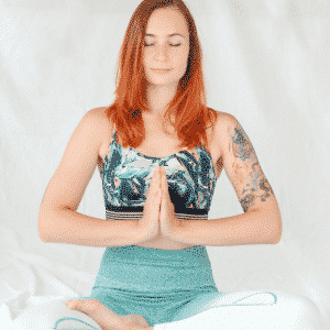 redheaded woman meditating in yoga pants