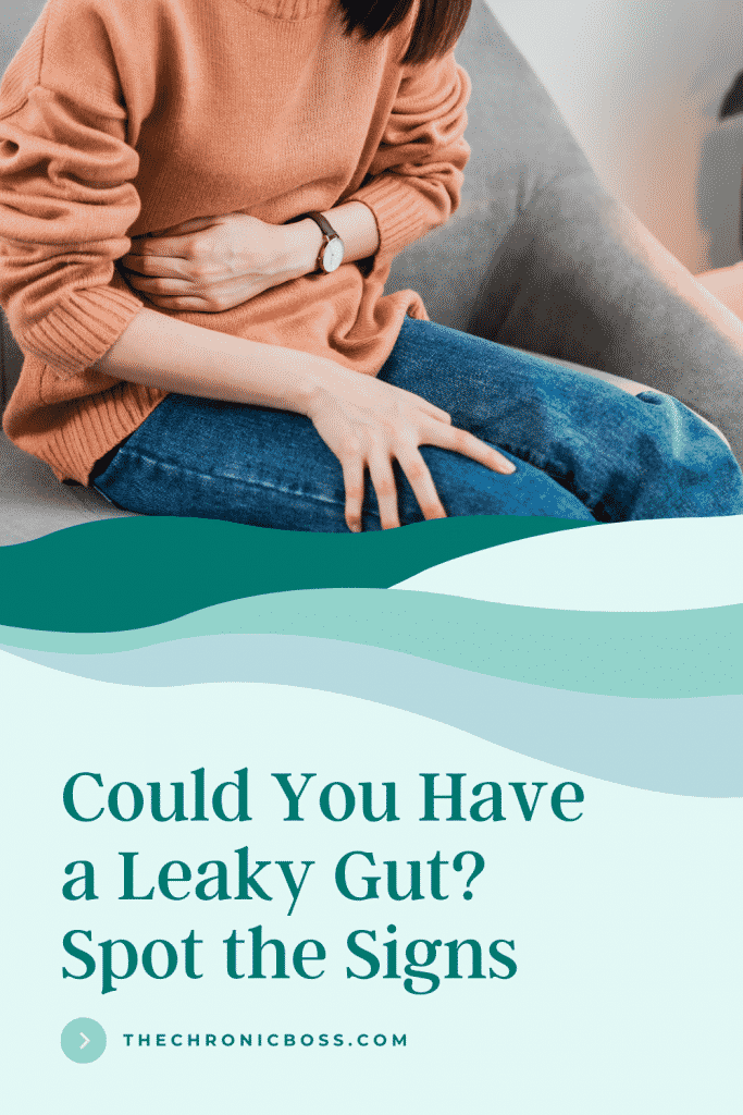 woman with orange sweater holding stomach pain from leaky gut